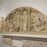La chiesa di Sant'Andrea di Barletta � rappresentata con una lunetta che presenta il tetramorfo, ossia una raffigurazione iconografica dell'immagine biblica dei quattro simboli evangelisti: un uomo alato, un leone, un bue (o un toro) e un'aquila. Questi simboli reggono le colonne che scandiscono lo spazio in cui c'� Cristo al centro con le dita a formare il numero tre, la trinit�, e ai lati due santi seguiti da due angeli inginocchiati